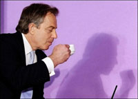 Prime Minister Tony Blair has a cup of tea during a discussion with health experts about future funding for the NHS at the 'Kings Fund' in London in April 2005. (AFP)