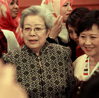 Vice premier Wu Yi poses for a group photo with women at home and abroad in Beijing in this March 7, 2006 file photo. [newsphoto]